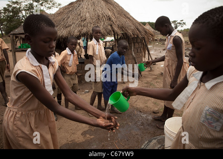 Les élèves se laver les mains avant un repas dans l'Amuria, Ouganda, Afrique de l'Est. Banque D'Images