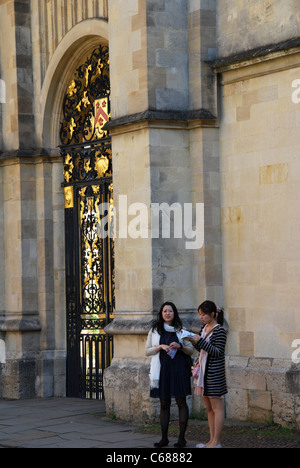 Deux touristes asiatiques en face de la porte de la poignée de l'All Souls College UK Oxford Radcliffe Camera en face Banque D'Images