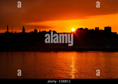 Coucher du soleil au bord de la mer, murs à Sahtouri, côte de la ville médiévale de Rhodes (site du patrimoine mondial par l'UNESCO), de la Grèce. Banque D'Images