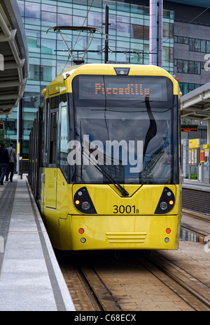 L'un des trams moderne jaune debout à une plate-forme à la gare de MediaCityUK Salford Quays (partie de la système Metrolink) Banque D'Images