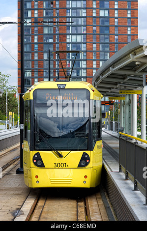 L'un des trams moderne jaune debout à une plate-forme à la gare de MediaCityUK Salford Quays (partie de la système Metrolink) Banque D'Images