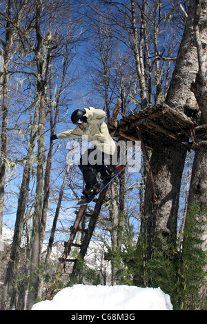 Snowboarder Jumping off tree fort à Termas de Chillan ski resort. Biobio, Chili, Amérique du Sud Banque D'Images
