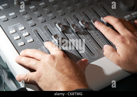 Les mains d'ingénieurs du son travaillant sur une platine de mixage dans un studio d'enregistrement Banque D'Images