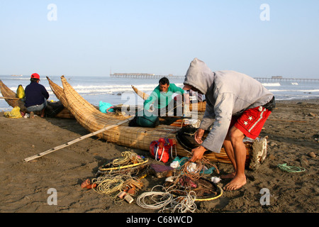 Caballitos de Totora reed pêcheurs préparent leurs filets pour une autre journée de pêche. Pimentel, Lambayeque, Pérou, Amérique du Sud Banque D'Images