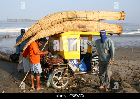 Caballitos de Totora reed bateaux chargés à bord d'un tuk tuk taxi du moteur sur la plage. Pimentel, Lambayeque, Pérou, Amérique du Sud Banque D'Images