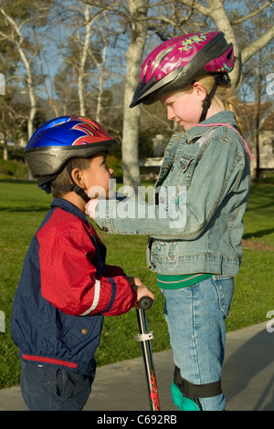 La diversité ethnique adoption divers Jeune fille 7-8 ans attache casque pour la pré-hispaniques frère K adopté. M. © Myrleen Pearson Banque D'Images