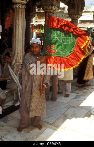 Les fidèles portent une bannière à l'Hazrat Nizamuddin Sufi culte, Delhi, Inde Banque D'Images