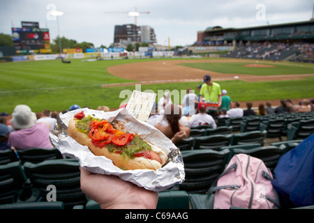 Holding hot dog et ticket jeu assis dans le stand à Shaw Park baseball stadium anciennement canwest accueil à Winnipeg Goldeyes Banque D'Images