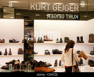 Un adolescent faisant des emplettes pour des chaussures dans la boutique de Kurt Geiger, terminal 3 de l'aéroport Heathrow de Londres, UK Banque D'Images