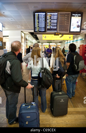 Les passagers de l'air à la recherche au conseil, 3 départs Terminal de l'aéroport Heathrow de Londres, UK Banque D'Images