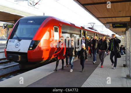 À plus grande vitesse rapide à une station de train de banlieue à la foule des passagers sur la plate-forme Banque D'Images