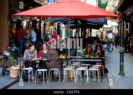 Des gens assis et boire du café sous un auvent rouge dans l'un des célèbres Melbourne des allées. L'Australie. Banque D'Images