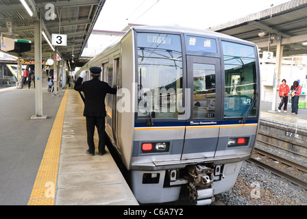 Garde d'un train de banlieue japonais le conducteur signale qu'il est sécuritaire de s'écarter. Train de voyageurs, le Japon. Banque D'Images