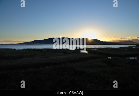 Le coucher du soleil. L'Encanyissada lagoon (El Montsià montagnes de l'arrière-plan). Delta de l'Ebre. Province de Tarragone. Espagne Banque D'Images