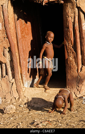 Enfants Himba en face de la Maison dans village près d'Opuwo, Namibie Banque D'Images