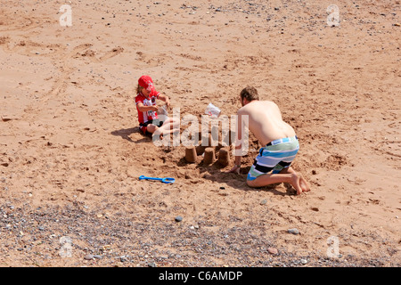 Un des châteaux de père sur la plage avec son fils dans le Devon en Angleterre Banque D'Images