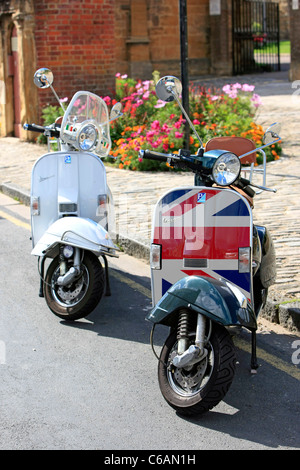 Une paire de scooters Vespa garé au bord de la route en Angleterre Banque D'Images