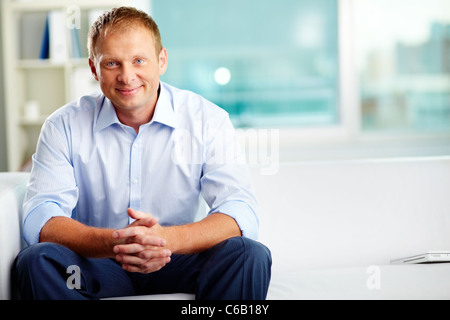 Portrait of smiling man sitting in office Banque D'Images