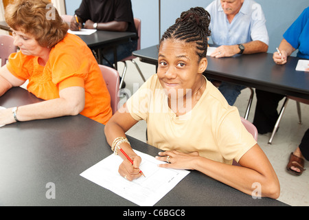 Jeune femme avec la paralysie cérébrale dans la classe du collège. Banque D'Images