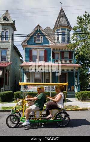 Les touristes à travers les rues charmantes de la pédale de Cape May, New Jersey, un monument historique national Banque D'Images