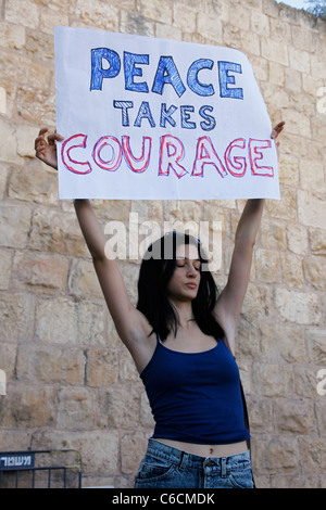 Un militant de la paix israélien est titulaire d'un signe qui se lit en carton prend le courage de la paix au cours d'un mouvement anti-nous talk show host Glenn Beck comme il a occupé sa 'courage' La restauration d'Israël à côté d'un lieu saint très controversée dans la vieille ville de Jérusalem Le Mur occidental de la mosquée Al-Aqsa et attire des centaines de partisans, pour la plupart des chrétiens évangéliques. Israël Banque D'Images