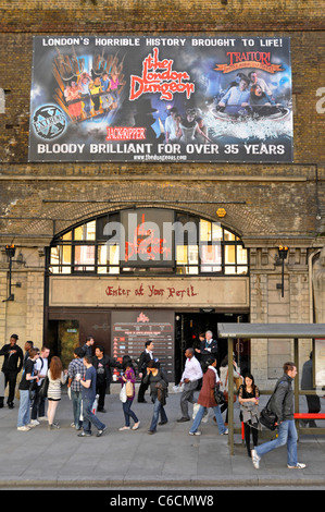 Scène de rue à Londres les gens et arrêt de bus devant le London Dungeon attraction touristique de passage de chemin de fer locaux dans le sud de Londres Southwark Tooley Street UK Banque D'Images