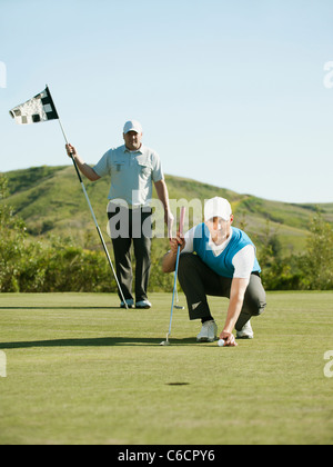 Caucasian golfer mise sur balle de golf course Banque D'Images