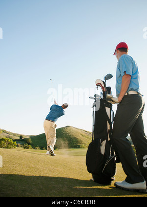 Les hommes jouer au golf sur le terrain de golf Banque D'Images