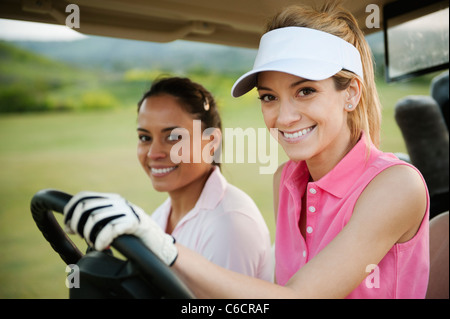 Les femmes au volant golf cart on golf course Banque D'Images