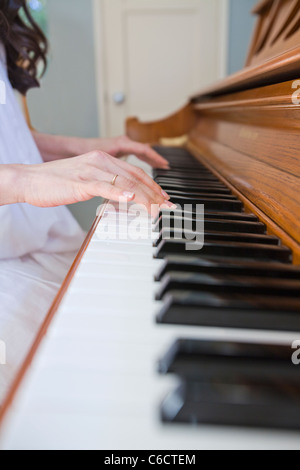 Close up of mixed race woman playing piano Banque D'Images