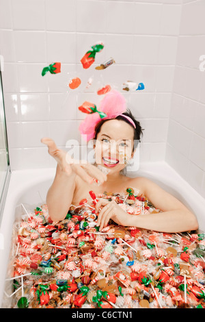 Mixed Race woman taking a bath en candy Banque D'Images