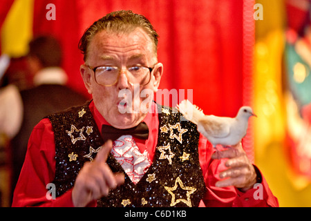 Un vieux magicien exécute une isappearing "colombe" dans la loi sur le parc d'Orange County Fair à Costa Mesa, CA. Banque D'Images