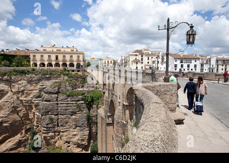 Jolie femme française pose sur le pont au-dessus de gorges profondes à Ronda en Espagne. Le trafic et les piétons traversent la vieille ville historique de pont. Banque D'Images