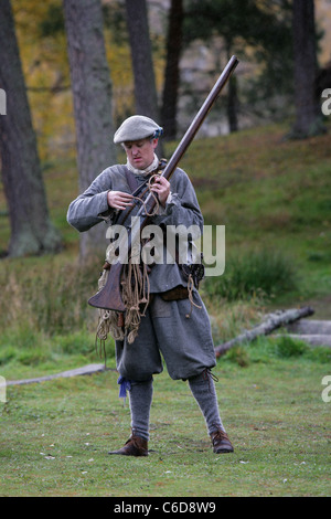 Membre de [Fraser's Dragoons], un 17e siècle re-enactment society, le chargement de son mousquet Banque D'Images