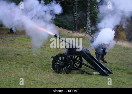 Membre de [Fraser's Dragoons], un 17e siècle re-enactment society, tirant un canon, canon de flammes et fumée de la culasse Banque D'Images