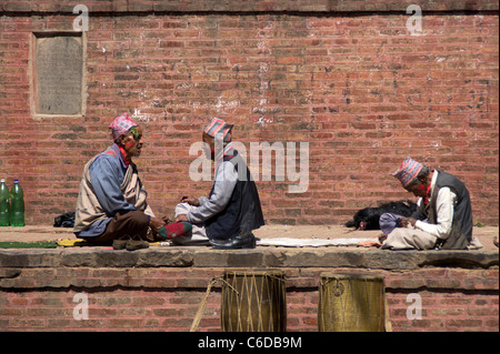 Trois hommes népalais assis sur un temple à Katmandou, Népal, Région du Centre Banque D'Images