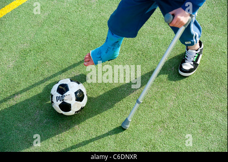 Garçon avec jambe cassée dans Cast avec des béquilles Banque D'Images