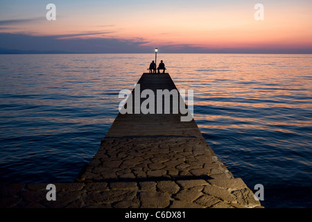 Pêcheurs sur une jetée au coucher du soleil, la Grèce, de Molivos Banque D'Images