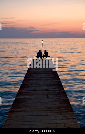 Pêcheurs sur une jetée au coucher du soleil, la Grèce, de Molivos Banque D'Images