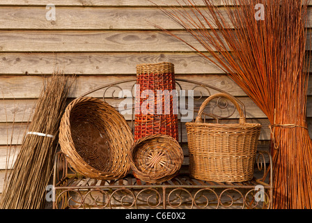 Fait à la main divers paniers de saule sur banc de jardin en métal rustique contre paroi de l'habitacle Banque D'Images