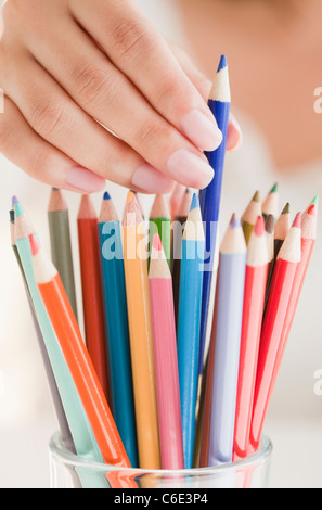 USA, New Jersey, Jersey City, Close up of woman's hand picking colorful crayons Banque D'Images