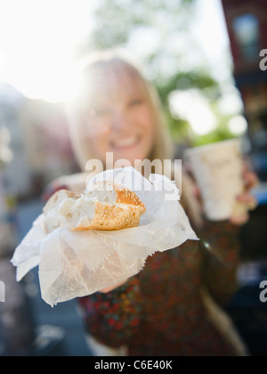 États-unis d'Amérique, Brooklyn, Williamsburg, Woman showing bagel Banque D'Images