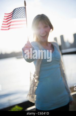 États-unis d'Amérique, Brooklyn, Williamsburg, Woman holding American flag Banque D'Images