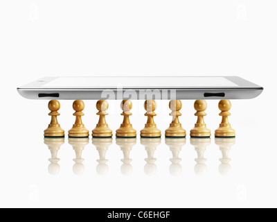 Tablette numérique sur les pions d'échecs en bois, studio shot Banque D'Images