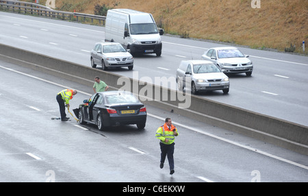 HIGHWAYS AGENCY AGENTS DE CIRCULATION s'occupe d'un automobiliste EN DÉTRESSE SUR LA VOIE RAPIDE DE L'autoroute M6 À LA SUITE D'UN ACCIDENT UK Banque D'Images