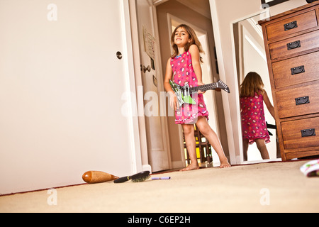 Mixed Race girl à jouer de la guitare dans la chambre Banque D'Images