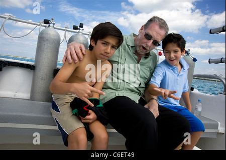 Peter Greenberg avec fils du Président Calderon sur le bateau à Cozumel, Mexique Banque D'Images