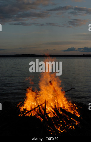 Feu de camp au milieu de l'été par le lac Paijanne, Finlande Banque D'Images