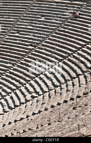 Deux touristes prendre dans la vue au théâtre grec classique à l'ancienne Epidaure, Argolid, Péloponnèse, Grèce. Banque D'Images