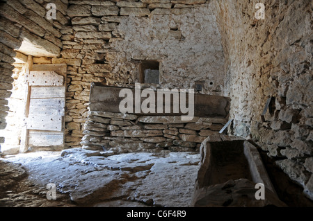 L'intérieur de l'ancienne étable avec mangeoire faite de pierres dans le village des Bories, à proximité de Gordes en Provence, France Banque D'Images